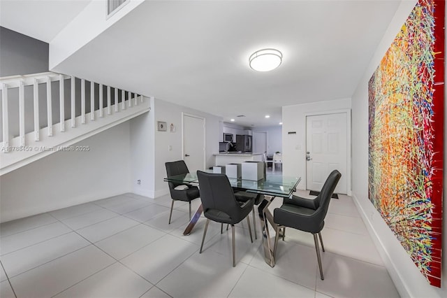 dining area featuring stairway, baseboards, visible vents, and light tile patterned floors