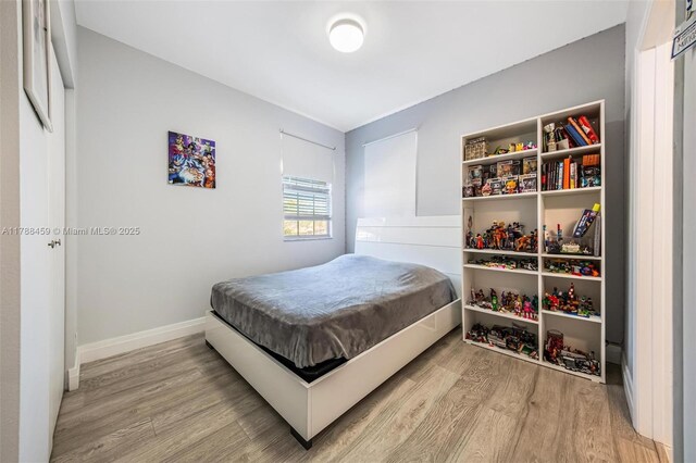 bedroom featuring baseboards and wood finished floors