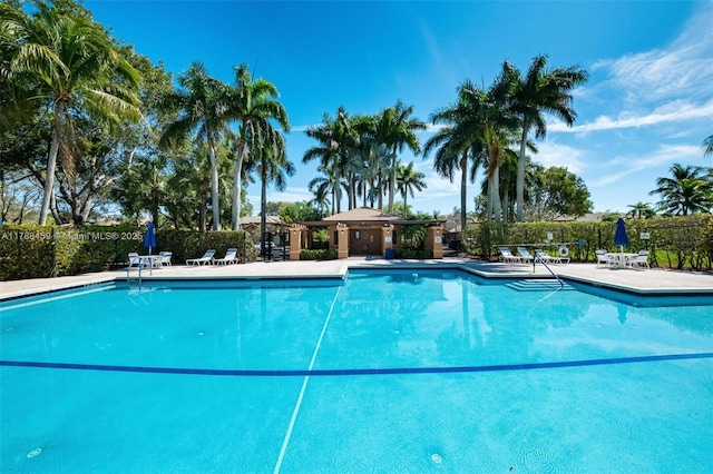 community pool with fence and a patio area