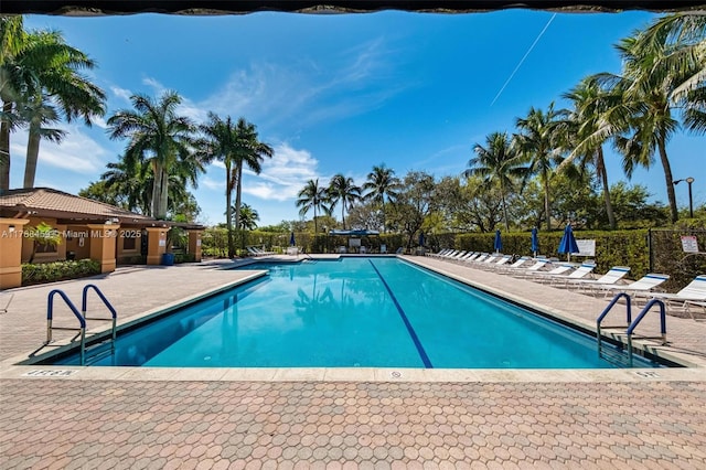 pool with a patio and fence