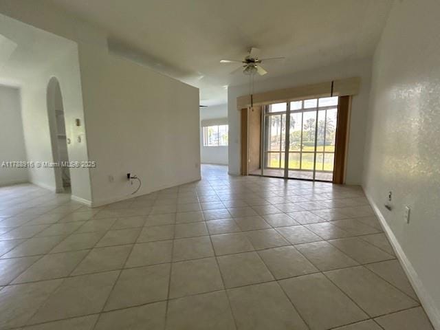 7911 W Exeter Blvd W Unit A101, Tamarac, FL 33321 - spare room featuring a ceiling fan, light tile patterned floors, baseboards, and arched walkways