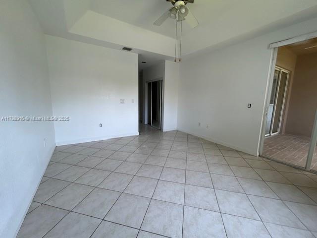 7911 W Exeter Blvd W Unit A101, Tamarac, FL 33321 - unfurnished room featuring light tile patterned floors, ceiling fan, and a raised ceiling