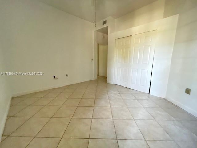 7911 W Exeter Blvd W Unit A101, Tamarac, FL 33321 - unfurnished bedroom with light tile patterned flooring and a closet