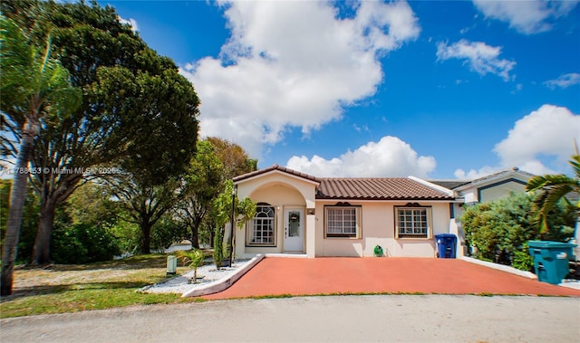 mediterranean / spanish-style home with stucco siding and a tiled roof