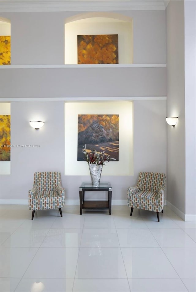 living area featuring ornamental molding, tile patterned floors, and baseboards