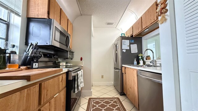 11657 NW 11th St, Pembroke Pines, FL 33026 - kitchen featuring stainless steel appliances, light countertops, brown cabinets, a sink, and light tile patterned floors