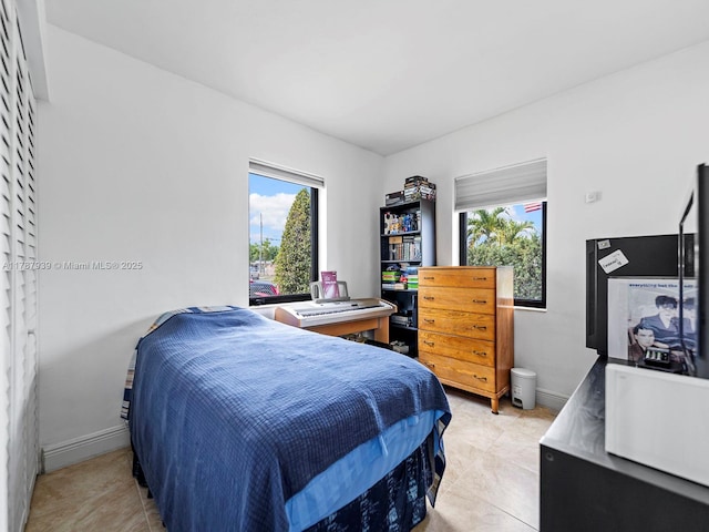 bedroom with baseboards and light tile patterned floors