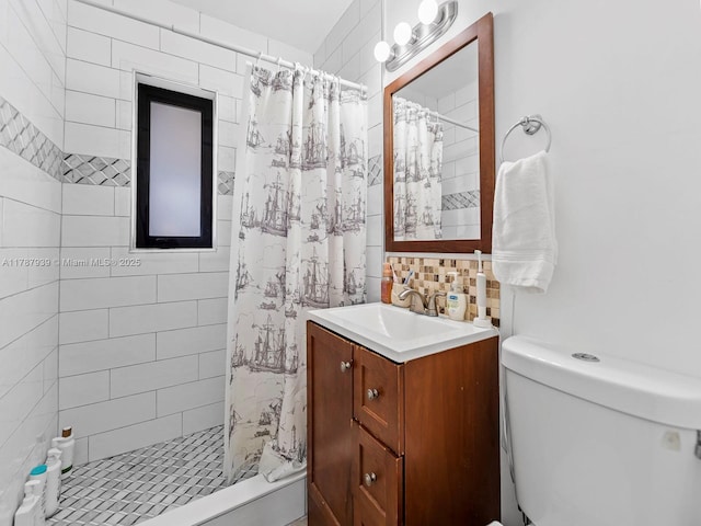 full bathroom featuring vanity, toilet, and tiled shower