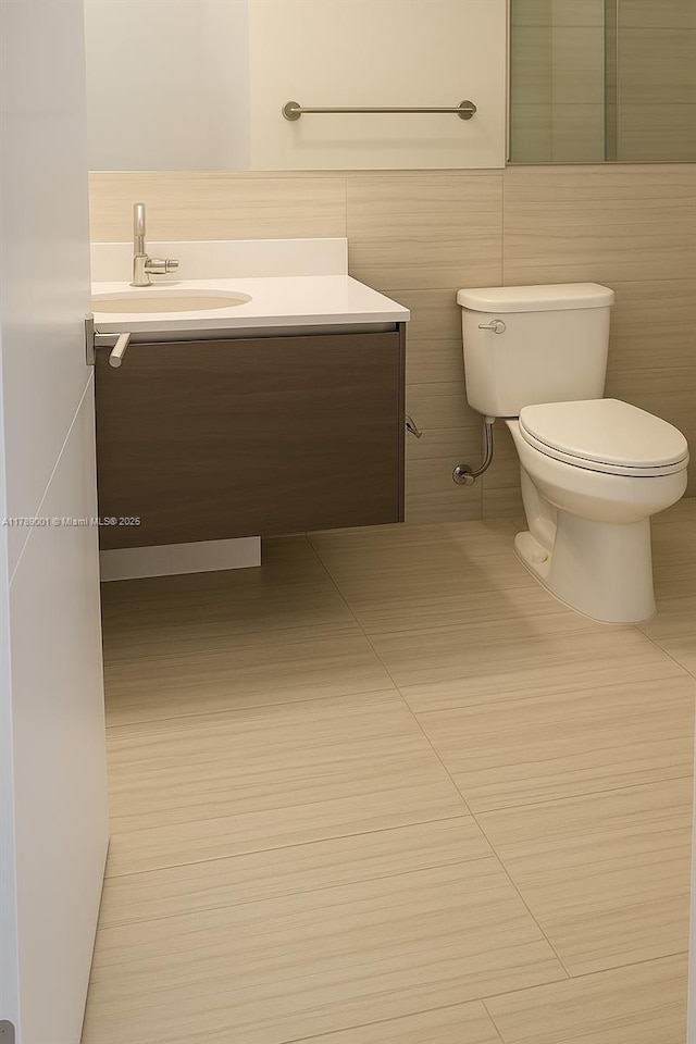 bathroom with toilet, vanity, and tile patterned flooring
