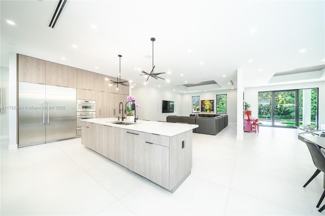 kitchen featuring stainless steel built in refrigerator, a large island, open floor plan, visible vents, and modern cabinets