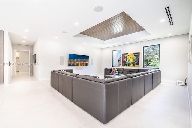 living room featuring baseboards, recessed lighting, visible vents, and a raised ceiling