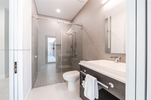 full bath featuring toilet, vanity, tile patterned floors, and a stall shower