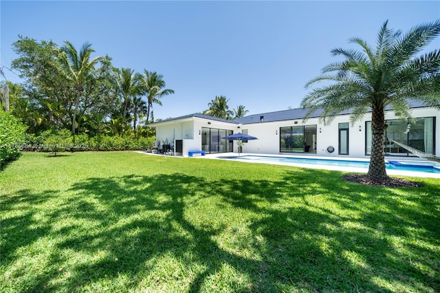 back of house with a yard, a patio, an outdoor pool, and stucco siding