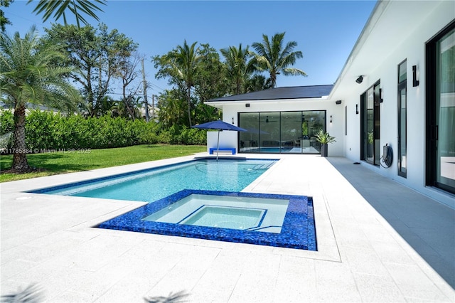 outdoor pool with a yard, a patio area, and an in ground hot tub