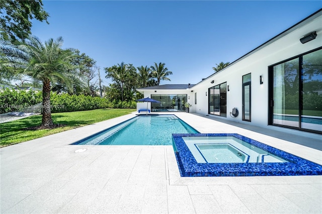 view of swimming pool featuring a yard, a patio area, and a pool with connected hot tub