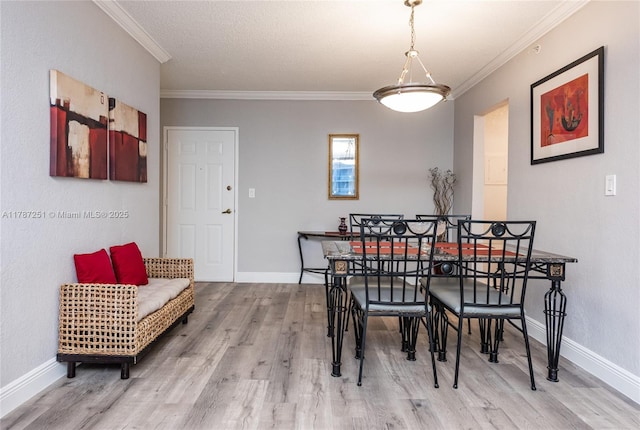 dining space with wood finished floors, ornamental molding, and baseboards