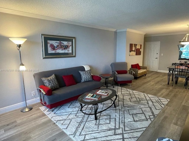 living room featuring baseboards, wood finished floors, a textured ceiling, and crown molding