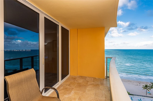 balcony featuring a beach view and a water view