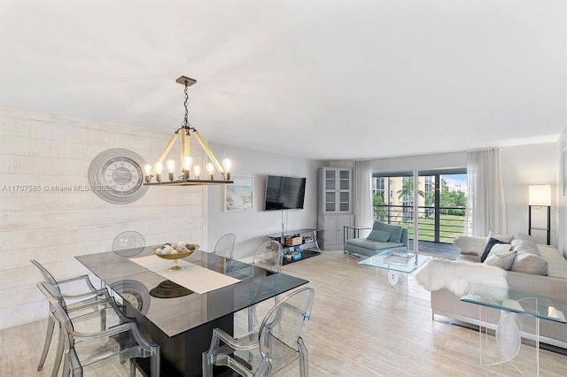 dining space featuring light wood-style floors and a chandelier