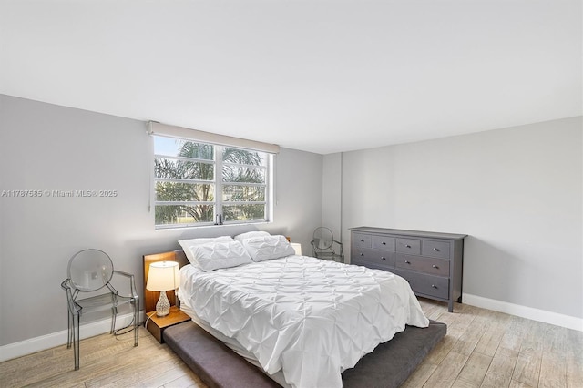 bedroom with light wood finished floors and baseboards