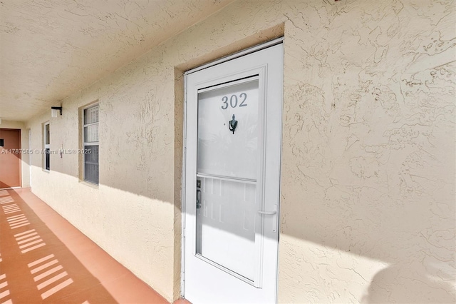 property entrance with stucco siding
