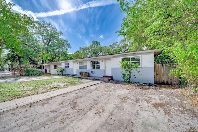 ranch-style home featuring fence