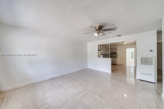 empty room with baseboards and ceiling fan