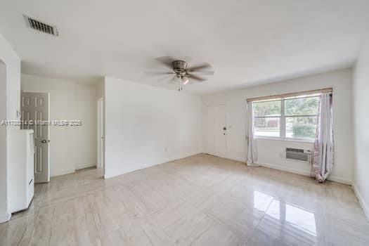 unfurnished room with a ceiling fan and visible vents