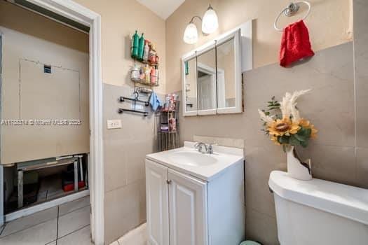 bathroom featuring tile patterned flooring, vanity, and toilet