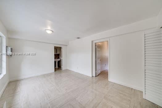 spare room with baseboards