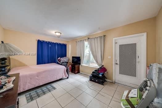 bedroom with baseboards and light tile patterned flooring