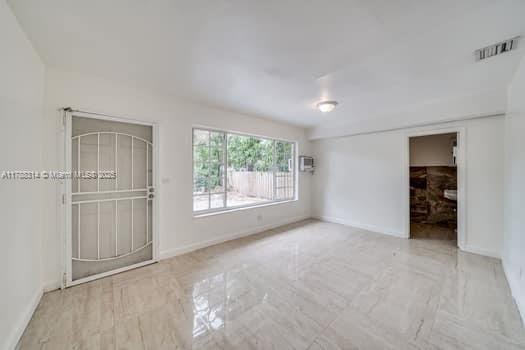 unfurnished room with visible vents and baseboards
