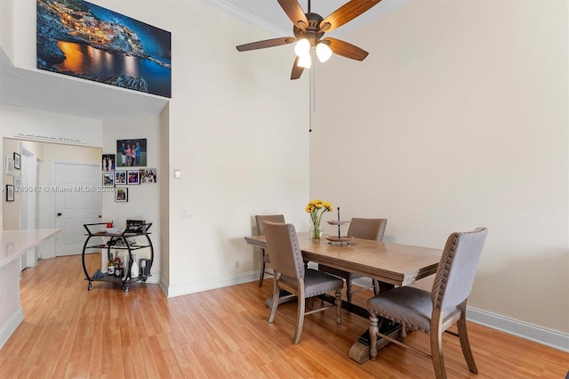 dining area with light wood-type flooring, baseboards, and ceiling fan