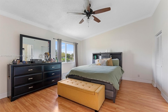 bedroom featuring vaulted ceiling, light wood-style floors, crown molding, baseboards, and a ceiling fan