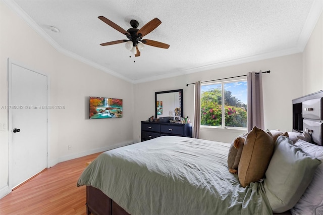 bedroom with lofted ceiling, light wood-style flooring, crown molding, a textured ceiling, and ceiling fan