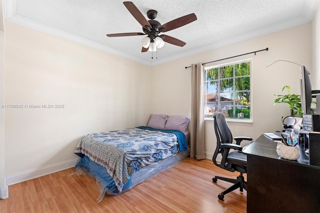 bedroom with wood finished floors, ornamental molding, baseboards, a desk, and a textured ceiling