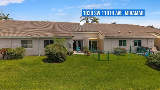 rear view of property with a tiled roof and stucco siding