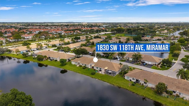 aerial view of property and surrounding area with a large body of water and nearby suburban area