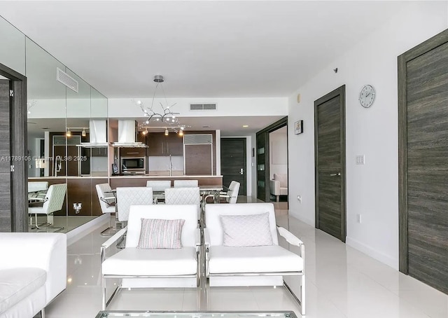 living area featuring light tile patterned flooring, visible vents, and a notable chandelier