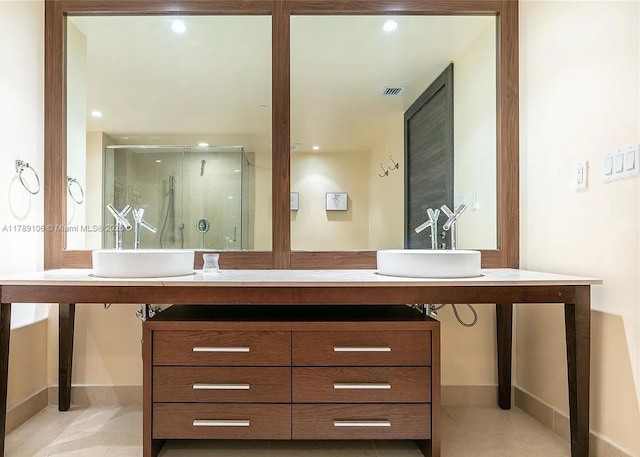 full bath featuring a shower stall, a sink, visible vents, and double vanity