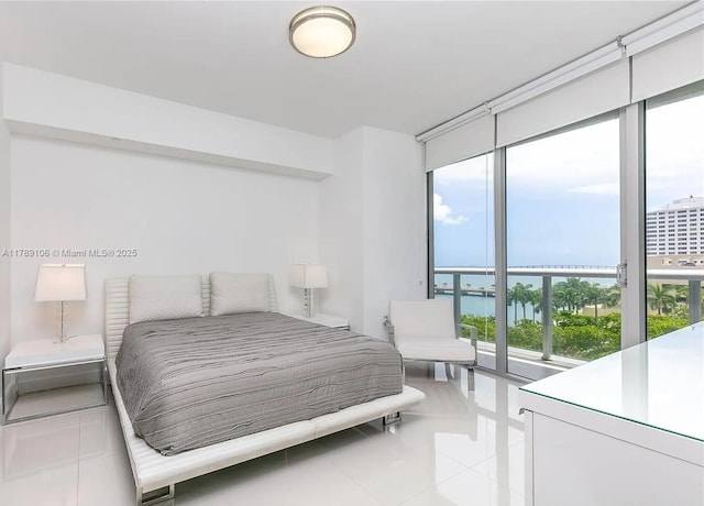 bedroom featuring floor to ceiling windows, a water view, and light tile patterned floors