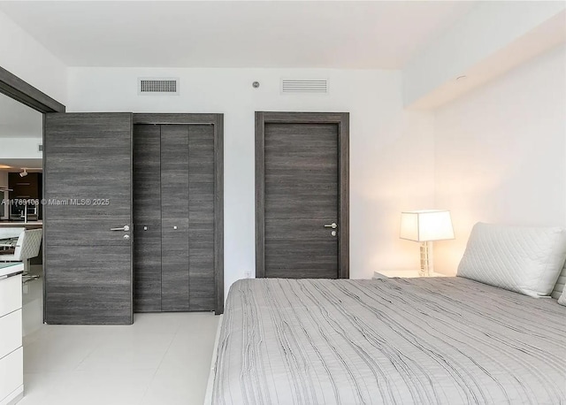 bedroom featuring multiple closets and visible vents