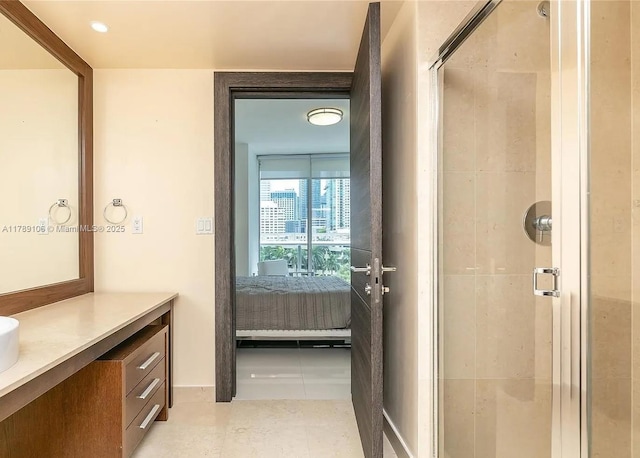 ensuite bathroom with vanity, tile patterned floors, a stall shower, and ensuite bathroom