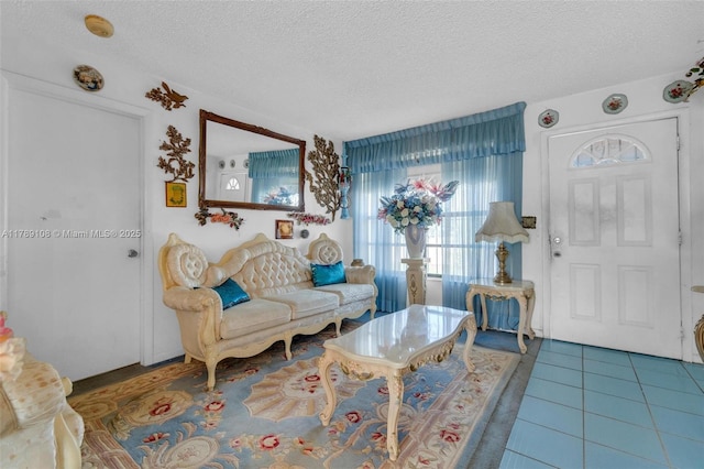 living area with a textured ceiling and tile patterned floors