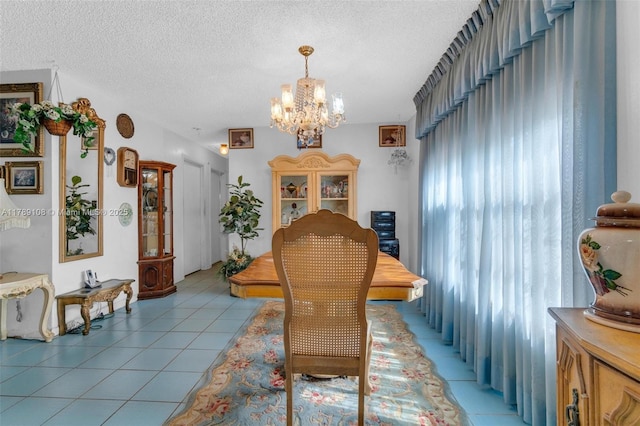 dining area with a textured ceiling, a notable chandelier, and light tile patterned floors
