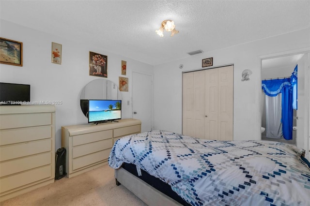 bedroom with a closet, a textured ceiling, visible vents, and light colored carpet