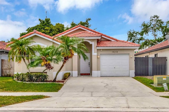 14214 SW 177th Ter, Miami, FL 33177 - mediterranean / spanish house with a tiled roof, driveway, fence, an attached garage, and stucco siding