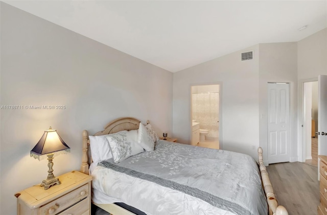 14214 SW 177th Ter, Miami, FL 33177 - bedroom with vaulted ceiling, baseboards, visible vents, light wood-style floors, and ensuite bath