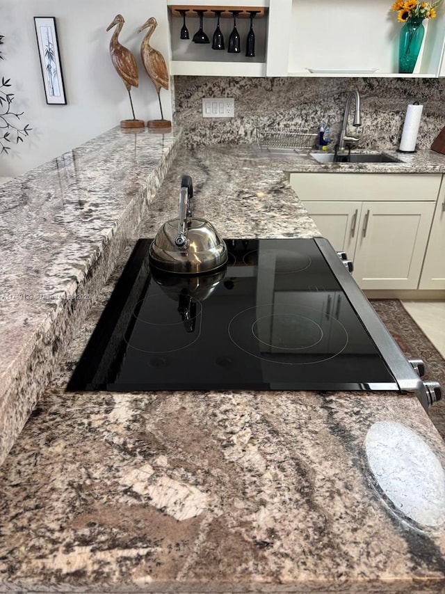 500 Three Islands Blvd Unit 313, Hallandale Beach, FL 33009 - kitchen with a sink, white cabinets, decorative backsplash, stovetop, and stone countertops
