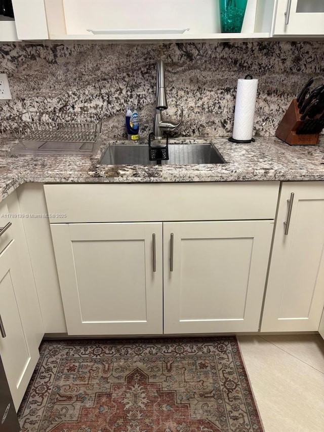 500 Three Islands Blvd Unit 313, Hallandale Beach, FL 33009 - detailed view of a sink, decorative backsplash, light stone counters, and white cabinets